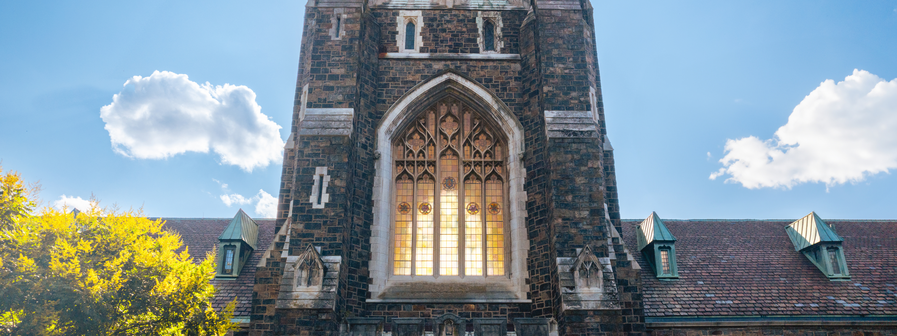 Alumni Hall's tower glows against a bright blue sky at Lehigh University